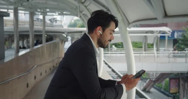 商人通过电话耳机在城市街道上进行交谈 男人带着坚定的决心讨论复杂的商业计划 商人专业精神 动态的工作企业家精神 — 图库视频影像