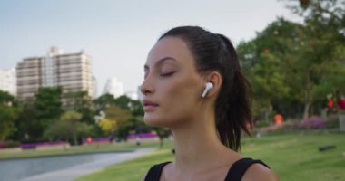 Yoga meditasyonunda kadın gözlerini kapatıyor. Şehir parkında dinleniyor. Her nefeste dişi, farkındalık meditasyon gücünü daha da derinlemesine araştırır ve duygusal sağlığa uyum sağlar.