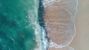 Okyanus dalgaları kumlu sahil tropikalleri üzerinde yuvarlanır doğa hava manzarası. Okyanus kıyısının güzelliği el değmemiş kumlar uçsuz bucaksız deniz dalgaları ritimli bir şekilde okyanus kıyısına vurur kıyı çevresinin cazibesine