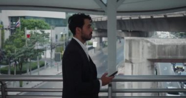 Kostümlü, orta yaşlı iş adamı cep telefonuyla şehir sokaklarında dolaşıyor. Milenyum işadamı profesyonel iş adamı şehir sokaklarını değiştiriyor şehir hayatının ritmini karıştırıyor