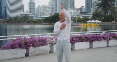 Antrenman öncesi olgun adam vücut parkını ısıtır fiziksel antrenmana hazırlanır. Her hareket kasıtlı olarak esneklik çevikliği üzerine odaklanarak performansı optimize etmek için vücut ısınmasını vurgular.