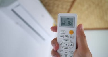 Klima uzaktan kumandasında yakın çekim tuşuna bas. Uzaktan kumandalı işletim modu ekipmanı seçiliName Pürüzsüz bir şekilde uzaktan kumanda optimal sıcaklık değeri ayarlandı