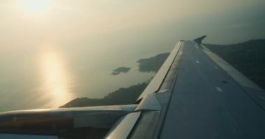Uçak penceresinden görkemli manzara güzel okyanus günbatımı kanadı uçağın uçsuz bucaksız gökyüzü kanadı kanat doğa harikaları. Güneş ufkun altına batar. Sakin okyanus uçağı gökyüzünün genişliği.