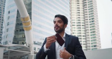 Banker aceleyle ofise doğru ilerliyor, saate bakıyor. Cep telefonunu aceleyle çıkarırken, bankacı saatin geç olduğunu fark etti. İzleme süresini aynı anda izlerken telefonu kulağa yerleştirir