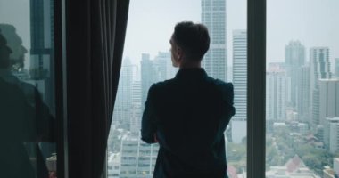 Kentsel apartmandaki adam aşağıdaki metropolde nefes kesici panoramik pencerelerden zevk alır. Panoramik pencereler, panoramik pencerelerle kentin ortasında huzur içinde yaşayan erkek şehrine benziyor.