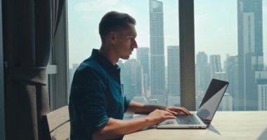 Milenyum programcısı kodlama konforlu ev ofisini araştırıyor. Merkez ofis orta yetişkin adam programcısı klavye kodlama teknolojisi programlama odası çalışması klavye yazma