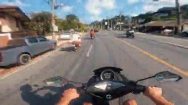 Koh Samui, Tayland - Temmuz 04, 2024: Süvarilerin gözlerinden görülen tropik güzellikte tropikal ada boyunca motosikletle seyahat. Zaman atlamasında birinci şahıs gözüyle tropikal adada bisiklet sürmek