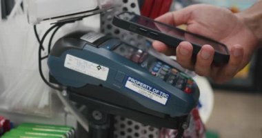 Marketteki banka terminalinin siparişini ödemek için akıllı telefon nakitsiz cüzdan teknolojisi kullanarak erkek eli kapatın. Temassız ödeme konsepti. Bangkok, Tayland - 02 Sep 2023