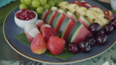Restoran masasında taze meyve ve böğürtlen tabağı var. Sağlıklı, taze meyve restoranı atmosferinde. Lokanta masasında taze meyve ve böğürtlen sergileniyor.
