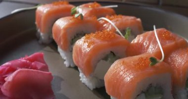 Lokanta masasındaki lezzetli suşi ruloları. Arzularınızı en iyi suşi deneyimiyle tatmin edin ve lezzetler dünyasına dalın. Suşi konsepti.