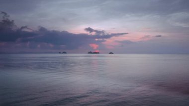 Sakin okyanus dağlarla ve gün batımı bulutlarıyla buluşur, parıldayan güzellik. Huzurlu tablo, doğanın ihtişamının, doğal güzelliği büyüttüğü huzurlu ve enerjik manzara. Güzeller kucaklaşır, doğa başyapıtı