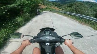 Koh Samui, Tayland - Temmuz 04, 2024: Canlı doğada bisiklet sürmenin verdiği heyecan üzerine motosiklet sürüşün birinci şahıs görüntüsü. Motosiklet yolculuğunun POV 'u Tropik ada boyunca Güzel yeşillik