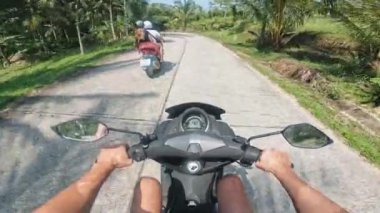 Koh Samui, Tayland - Temmuz 04, 2024: Traversing Rich 'in koltuk macerasından nefes kesici manzaralı tropikal adada motosiklet süren kişi. Motosikletçi, tropikal ada birinci şahıs perspektifinde seyahat ediyor.