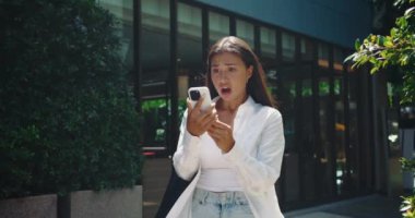 Genç yetişkin bir kadın kentte durup telefona bakarken hayal kırıklığına uğruyor ve kişisel duygusal kargaşa arasındaki farkın altını çiziyor. Bireysel tatminsizlik anları