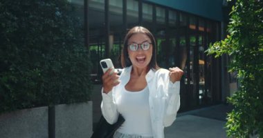 Telefondaki olumlu mesajı okuduktan sonra kadın mutluluk dolu sevinç ve memnuniyet dolu ışıltılarla karşılaşıyor. Kadın telefonuna bakar. Duyguları zevk ve memnuniyete kayar.
