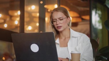 Proje detaylarını internette tartışan kadın, modern kafede dizüstü bilgisayara yönelen kadın, yaratıcılığı ve ortaklığı körükleyen sohbet, gerçek zamanlı dijital işbirliğinin güçlü tasviri