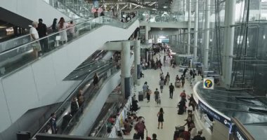 Bangkok, Tayland - 05 Mayıs 2024: Meşgul yolcularla dolu kalabalık havaalanı terminali, kapı arayan gezginler, tatil telaşı içinde seyahat eden gezginler, küresel hareketlilik ve canlı kültürel değişim