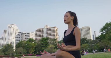 Şehir parkındaki kadın sakin meditasyon, meditasyon odaklanma ve denge getiriyor, meditasyonu günlük farkındalığa güç katıyor, dünya çapında sağlık ve sağlık kampanyaları için mükemmel.