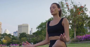 Zengin şehir parkında farkındalık yapan bir kadın, zihinsel berraklığı teşvik eden bir farkındalık, daha derin kendi kendine bağlantı kurma, sağlık kanalları ve kentsel geri çekilme promosyonları için mükemmel.