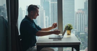 Şehir siluetiyle uzaktan kumandalı başarılı adam, esnek kariyeri besleyen uzak görevler, modern verimliliği ve küresel bağlantıları destekleyen uzak zihniyet, profesyonel başarı hikayeleri için mükemmel.