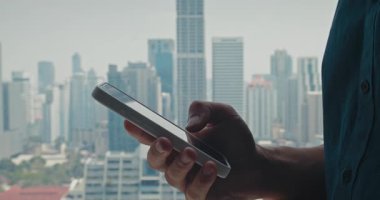 Akıllı telefonu kullanarak önemli güncellemeleri tarayan adam, akıllı telefon ile genişleyen şehirde yer değiştiren görevleri takip eden adam, hızlı dijital iş akışını gösteren akıllı telefon, kentsel iş temaları için ideal
