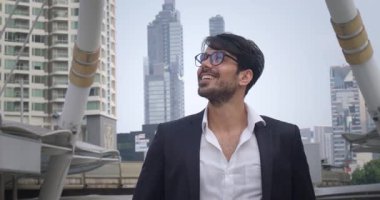 Şık takım elbiseli ve gözlüklü yönetici Metropolis 'te gökdelenlere bakarken gülümsüyor. Yüksek binalara bakan adam Panorama şehrinin camlarını inceliyor.