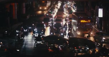 Bangkok, Tayland - 05 Mayıs 2024: Yoğun şehirde gece trafik sıkışıklığı, modern koşuşturmayı yansıtan trafik sıkışıklığı, parlak far ve kornalarla yoğunlaşan trafik sıkışıklığı, yoğun kaos