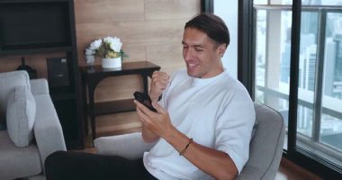 Mutlu heyecanlı Kafkasyalı zaferi telefon kazanıp haykırarak kazandı. Zafer konsepti. Milenyum erkeği, ev telefonlarının başarısı hakkında iyi haberler alıyor..