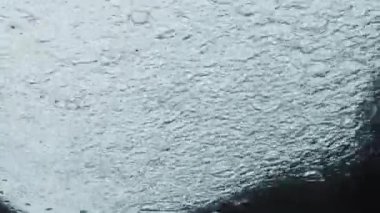 Sinematik açıdan yağmur fırtınası güzelliği. Yağış sularının dokulu yüzeyden aşağı akması karmaşık soyut damlacıklar ve nehir damlacıkları deseni oluşturur ve büyüleyici bir görüntüde sağanak yağışların özünü yakalar.