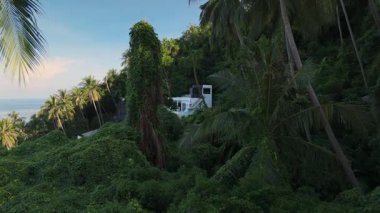 Beyaz Saray, tropikal ormanda saklı. Bereketli palmiye ağaçları ve yoğun bitki örtüsüyle çevrili lüks beyaz villa ışıl ışıl okyanusa bakıyor, dingin ve tenha tropikal bir cennet.