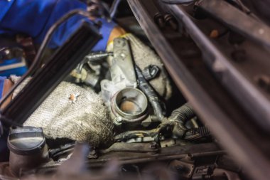 Otomobil tamircisi otomobil tamir atölyesinde çalışır ve araçları çalışır..