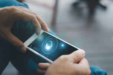 Holding a smartphone with a digital interface hologram of a padlock, virtual globe, robot face, and finger print is a businessman dressed in formal attire. cybersecurity and modern technology concepts