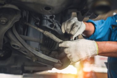 automobile suspension diagnostics, auto mechanic touches suspension arms and silent blocks