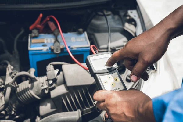 汽车机械师使用万用表电压表来测量汽车电池的电压 — 图库照片
