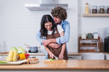 Sarılmak, mutfakta yemek pişirmek ve aşkta özel bir anın tadını çıkarmak. Sarılmak, aşklarını sevmek, ve birlikte kaygısız olmak, romantik bir sevgili ve sevgili.