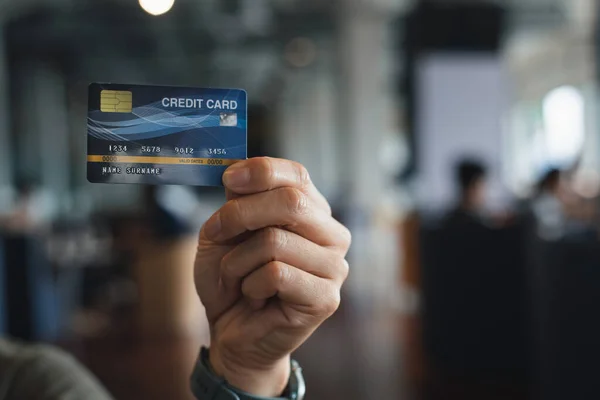 在办公室里 一个商人手里拿着一张假信用卡 信用卡显示现金付款已经过时 — 图库照片