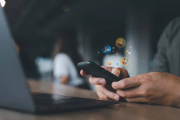 Sosyal medya pazarlama kavramını kullanan bir cep telefonu kullanıcısı, ekranda gösterilen sırıtma, mesaj, yorum ve yıldız bildirim simgeleri.