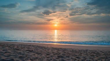 Kumsalda deniz kumu. Plajın panoramik manzarası. Tropik bir plajın ilham verici ufku. Gün batımında sakin, huzurlu ve altın sarısı bir gökyüzü. tatil için tatil afişi