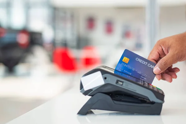 信用卡付款 在信用卡阅读器前持假信用卡购买和销售商品和服务 — 图库照片