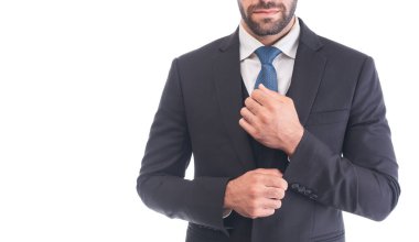 Beyaz bir arka planda kameraya gülümseyen uzun boylu, beyaz takım elbiseli beyaz bir adamın portresi. Kendine güvenen bir işadamı CEO, serbest çalışan ya da yönetici, metin için kopyalama alanı.