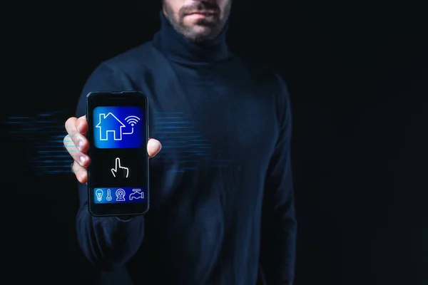 Concept for smart house technology. A holographic representation of a glowing digital security home lock appears on the smartphone in a businessperson\'s hands. Automated home security system software.