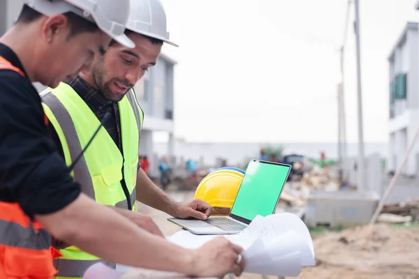 Construction sites for commercial and industrial buildings are inspected by two specialists. Civil engineer and investor working on a real estate project using a laptop, copy space for text