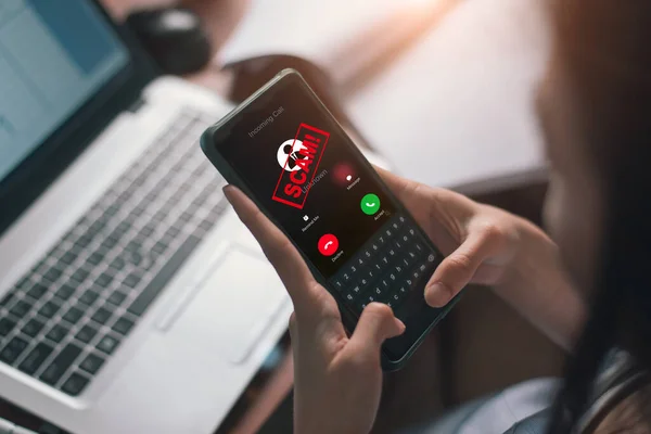 Potansiyel bir dolandırıcılık ihbarı alan kişi, telefon ekranında dolandırıcılık uyarısı yapıyor.