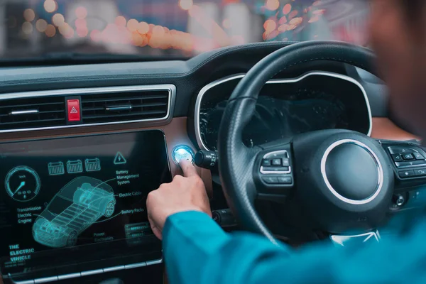 Driver activating start button on an electric car\'s interactive dashboard at dusk