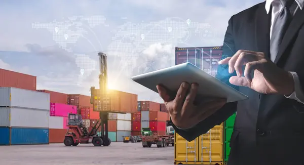 A professional man uses a tablet to manage and track shipping containers, with a futuristic global logistics network overlay