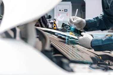 Eldivenlerdeki teknisyen, holografik tanı ve onarım verileri ile birlikte gelecekteki dijital tablet arayüzünü kullanarak araba motorunu inceliyor..