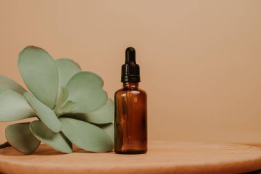 Bej rengi boş arkaplan serumu için cam şişe.