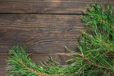 Çam kozalağı ve yeşil dal ahşap masa üzerinde kar, metin için kopyalama alanı. Ahşap arka planda çam kozalakları..