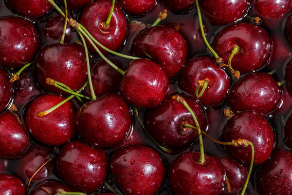 Cherry background.Close up of a bunch of bright red cherries shot from above. Cherry with drops. Food background.