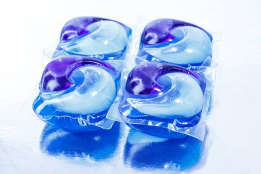 Beyaz arka planda çamaşır makinesi için deterjanlı kapsüller. Jel kapsülleri. Bulaşık makinesi..